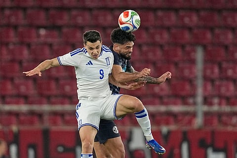 Greece's Anastasios Douvikas, left, challenges for the ball with Paraguay's Omar Alderete during the international friendly soccer match between Greece and Paraguay in Piraeus, Greece.
