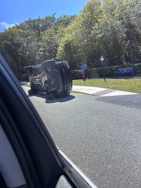 Golfer Tiger Woods stands by his overturned vehicle in Jupiter Island, Florida.