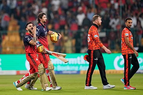 Royal Challengers Bengaluru's Virat Kohli, left, gestures to the fans as he walks out with teammate Tim David after winning the Indian Premier League cricket match against Sunrisers Hyderabad in Bengaluru, India, Saturday, March 28, 2026.
