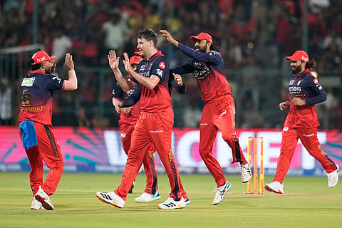 Royal Challengers Bengaluru's Jacob Duffy, center, celebrates with teammates the wicket of Sunrisers Hyderabad's Travis Head during the Indian Premier League cricket match between Royal Challengers Bengaluru and Sunrisers Hyderabad in Bengaluru, India.