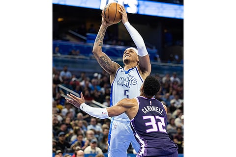Orlando Magic forward Paolo Banchero (5) takes a shot over Sacramento Kings center Dylan Cardwell (32) during the second half of an NBA basketball game in Orlando, Fla.