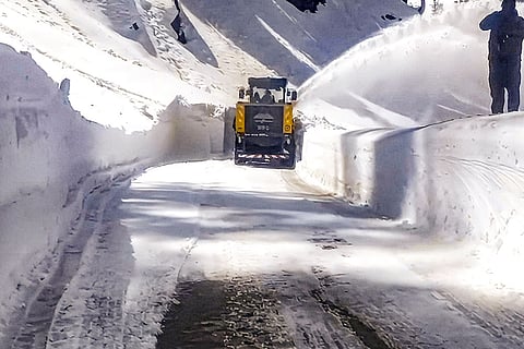 A snow-cutter blower clears snow on the Bhaderwah-Pathankot road, in Doda district, Jammu and Kashmir.