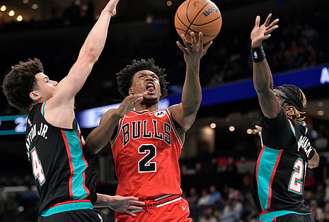 Chicago Bulls guard Collin Sexton (2) shoots between Memphis Grizzlies guards Walter Clayton Jr. (4) and Jahmai Mashack, right, in the first half of an NBA basketball game in Memphis, Tennessee.