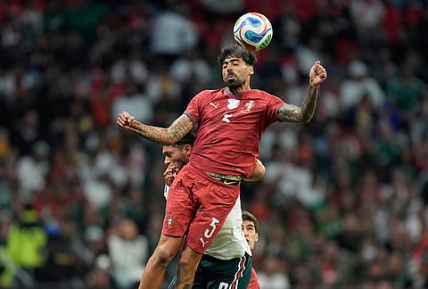 Portugal's Samu Costa, top, heads the ball challenged by Mexico's Raul Jimenez during the international friendly soccer match between Mexico and Portugal in Mexico City.