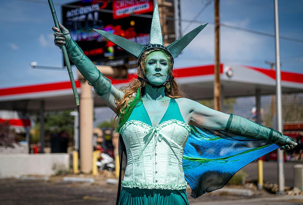 | Photo: Jessica Baca/The Albuquerque Journal via AP : Carrie Chavez, dressed as the Statue of Liberty, participates in a "No Kings" march on Montgomery Blvd in Albuquerque, New Mexico.
