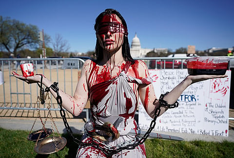 A demonstrator covered in fake blood attends a rally on the National Mall during the No Kings protest in Washington.
