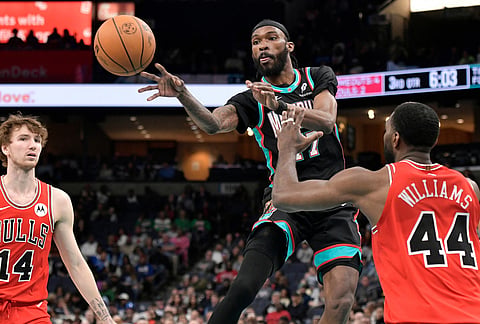 Memphis Grizzlies guard DeJon Jarreau (77) passes the ball between Chicago Bulls forwards Patrick Williams (44) and Matas Buzelis (14) in the second half of an NBA basketball game in Memphis, Tennesee.