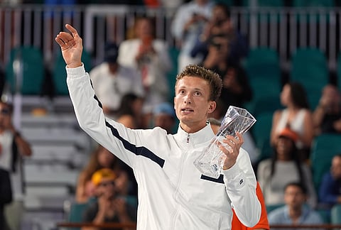 Jiri Lehecka of the Czech Republic waves to fans as he holds up his finalist trophy after losing to Jannik Sinner of Italy in the men's singles final at the Miami Open tennis tournament, in Miami Gardens, Florida.