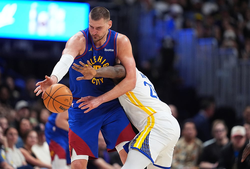 | Photo: AP/David Zalubowski : Denver Nuggets center Nikola Jokić, left, struggles to field a pass as Golden State Warriors forward Draymond Green defends in the second half of an NBA basketball game in Denver. 