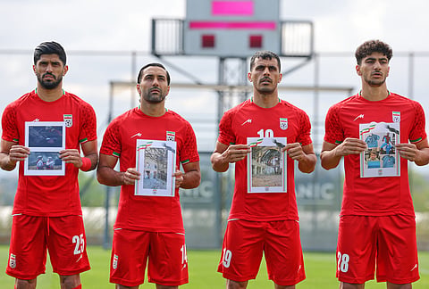 Iran's players sing the national anthem, holding pictures of children allegedly killed in U.S. and Israel strikes in Iran, before a friendly soccer match between Iran and Costa Rica, in Antalya, southern Turkey.