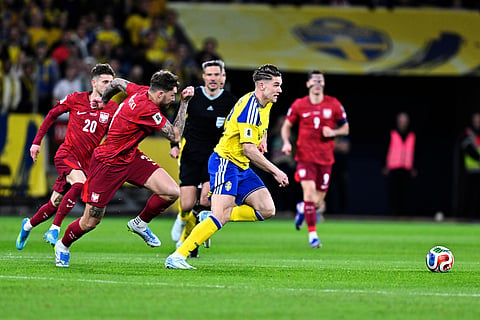 Poland's Sebastian Szymanski and Przemyslaw Wisniewski chase Sweden's Viktor Gyokeres during a World Cup qualifying playoff final soccer match.