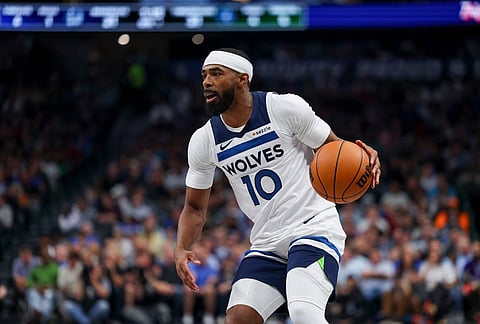 Minnesota Timberwolves guard Mike Conley looks to pass the ball in the first half of an NBA basketball game against the Dallas Mavericks, in Dallas.