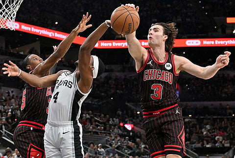 Chicago Bulls guard Josh Giddey (3) blocks a shot-attempt by San Antonio Spurs guard De'Aaron Fox (4) during the first half of an NBA basketball game, in San Antonio.