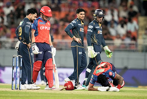 Punjab Kings' captain Shreyas Iyer, right, rolls on the ground in pain after getting hit by a shot from batting partner Cooper Connolly, second left, during the Indian Premier League cricket match between Gujarat Titans and Punjab Kings in New Chandigarh.