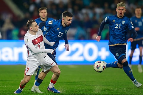 Turkey's Kerem Akturkoglu and Kosovo's Kreshnik Hajrizi challenge for the ball during the World Cup qualifying playoff final