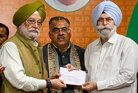 Union Minister Hardeep Singh Puri gives the party ticket to senior Supreme Court advocate and former AAP leader HS Phoolka after he joined the BJP, at the party headquarters, in New Delhi.