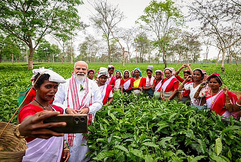 Prime Minister Narendra Modi poses for photographs with women workers at a tea garden, in Dibrugarh, Assam. 