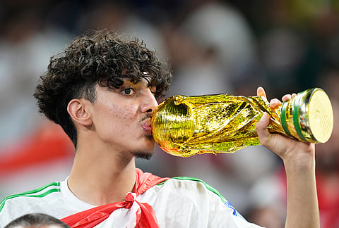 An Iraq's fan kisses a replica of the World Cup trophy prior to the World Cup playoff final soccer match between Iraq and Bolivia in Monterrey, Mexico.