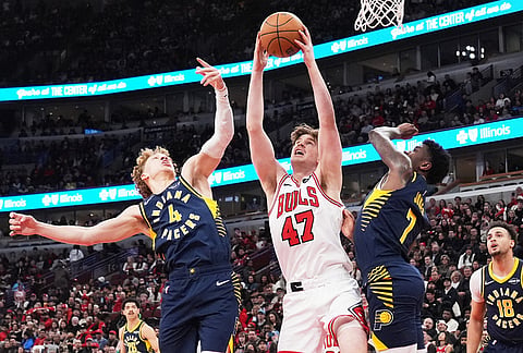 Chicago Bulls center Lachlan Olbrich (47) rebounds a ball against Indiana Pacers guard Taelon Peter, left, and guard Kam Jones during the first half of an NBA basketball game in Chicago.