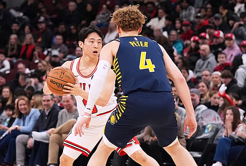 Chicago Bulls guard Yuki Kawamura, left, of Japan, looks to a pass against Indiana Pacers guard Taelon Peter during the first half of an NBA basketball game in Chicago.