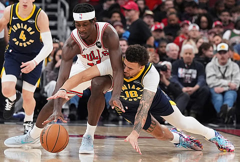 Chicago Bulls forward Leonard Miller, left, and Indiana Pacers forward Jalen Slawson battle for a loose ball during the second half of an NBA basketball game in Chicago.