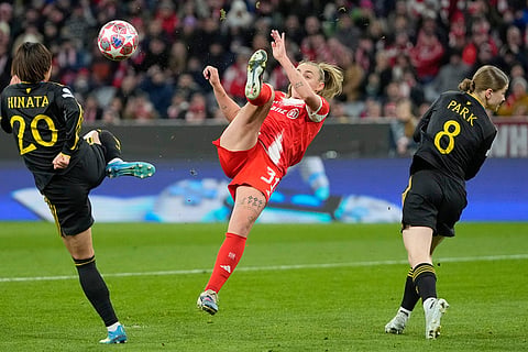 Bayern's Georgia Stanway, centre, vies for the ball with with Manchester United's Hinata Miyazawa during the Women's Champions League quarterfinal second leg soccer match between Bayern Munich and Manchester United in Munich, Germany.
