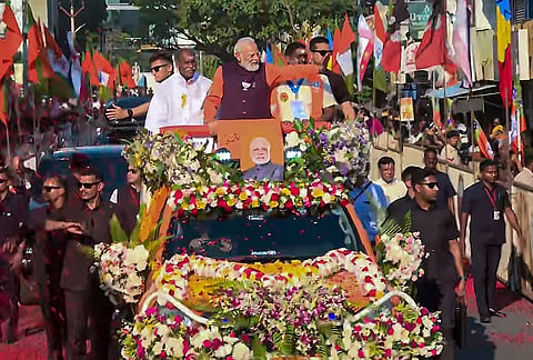 Prime Minister Narendra Modi greets supporters during a roadshow ahead of the Puducherry Assembly elections in Puducherry. 