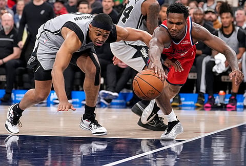 San Antonio Spurs forward Keldon Johnson, left, and Los Angeles Clippers guard Bennedict Mathurin go after a loose ball during the second half of an NBA basketball game in Inglewood, California.