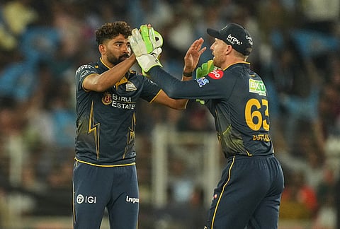 Gujarat Titans Mohammed Siraj, left, and Jos Buttler celebrates the wicket of Rajasthan Royals' Dhruv Jurel during the Indian Premier League cricket match between Gujarat Titans and Rajasthan Royals in Ahmedabad.