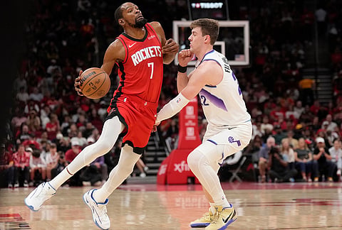Houston Rockets forward Kevin Durant (7) runs into Utah Jazz forward Kyle Filipowski, right, during the first half of an NBA basketball game, in Houston. 