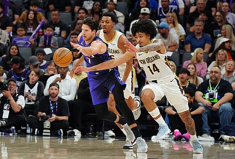 Sacramento Kings forward Doug McDermott (7) fights for the ball with New Orleans Pelicans guard Micah Peavy (14) during the second half of an NBA basketball game in Sacramento, California. New Orleans Pelicans forward Trey Murphy III (25) is at rear. 