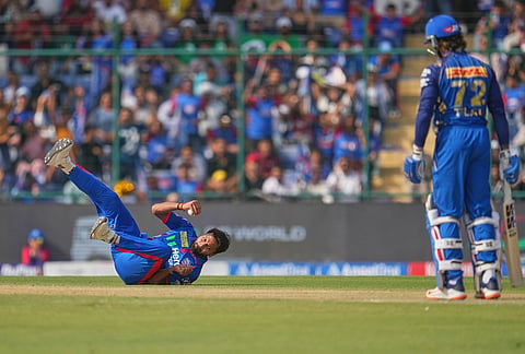 Delhi Capitals' Mukesh Kumar takes the catch to dismiss Mumbai Indians' Tilak Verma during the Indian Premier League cricket match between Delhi Capitals and Mumbai Indians in New Delhi.