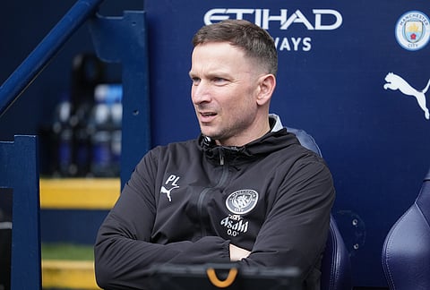 Manchester City assistan manager Pepijn Lijnders sits on the bench during the FA Cup quarter-final soccer match between Manchester City and Liverpool in Manchester, England.