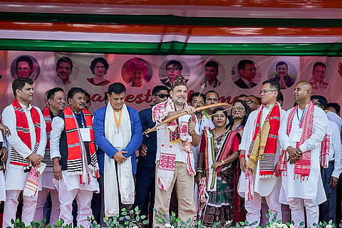 In this image posted on April 5, 2026, Lok Sabha Leader of Opposition and Congress MP Rahul Gandhi, centre, holds a bow and an arrow during a public meeting ahead of Assam Assembly Election. Assam Congress President and candidate from Jorhat constituency Gaurav Gogoi, second right, is also present.