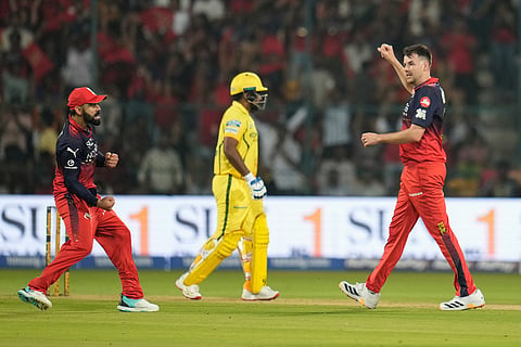Royal Challengers Bengaluru's Virat Kohli, left, celebrates with teammate Jacob Duffy the wicket of Chennai Super Kings' Sanju Samson, center, during the Indian Premier League cricket match between Chennai Super Kings and Royal Challengers Bengaluru in Bengaluru, India.