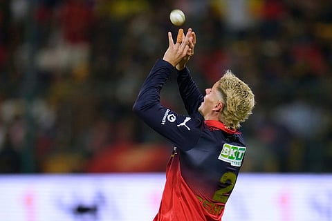 Royal Challengers Bengaluru's Jacob Bethell takes the catch to dismiss Chennai Super Kings' Jamie Overton during the Indian Premier League cricket match between Chennai Super Kings and Royal Challengers Bengaluru in Bengaluru, India.