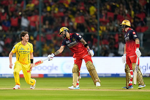 Royal Challengers Bengaluru's Virat Kohli, center, playfully taps Chennai Super Kings' Matthew Short, left, after the latter lost his balance while fielding the ball during the Indian Premier League cricket match between Chennai Super Kings and Royal Challengers Bengaluru in Bengaluru, India