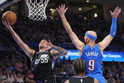 Utah Jazz guard John Konchar (55) looks to score past Oklahoma City Thunder guard Alex Caruso (9) during the second half of an NBA basketball game in Oklahoma City.