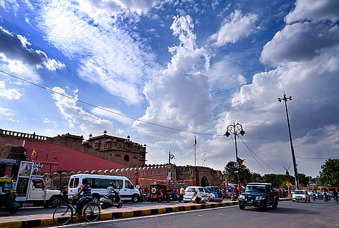 Clouds loom over Junagarh Fort as traffic moves along a city road, in Bikaner.