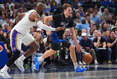 Dallas Mavericks forward Cooper Flagg, right, drives against Los Angeles Lakers forward LeBron James (23) during the the second half of an NBA basketball game in Dallas.