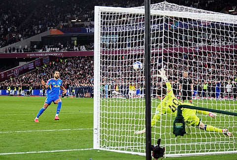 Leeds United's Dominic Calvert-Lewin, left, scores in the penalty shoot-out during the English FA Cup quarterfinal soccer match between West Ham United and Leeds United, in London.