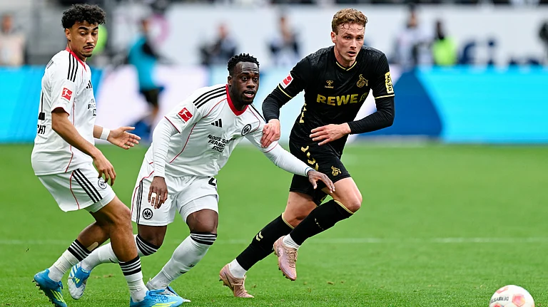 Cologne's Sebastian Sebulonsen, right, and Frankfurt's Nathaniel Brown, left, and Arnaud Kalimuendo battle for the ball during the German Bundesliga soccer match between Eintracht Frankfurt and 1. FC Cologne in Frankfurt, Germany, Sunday, April 5, 2026. - | Photo: dpa/Uwe Anspach via AP