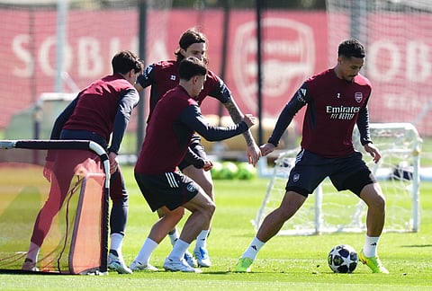 Arsenal's William Saliba, right, and team-mates practice during a training session in London, one day ahead of their Champions League, first leg, quarter-final soccer match against Sporting Lisboa. 