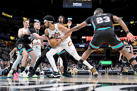 Cleveland Cavaliers center Jarrett Allen, center, handles the ball between Memphis Grizzlies guard Cam Spencer (24), forward Cedric Coward (23) and guard Adama Bal in the first half of an NBA basketball game in Memphis, Tenn.