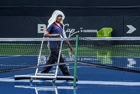 A ground staff member clears rainwater from the hard courts ahead of the Billie Jean King Cup Asia/Oceania Group I tournament, at DLTA Stadium, in New Delhi.