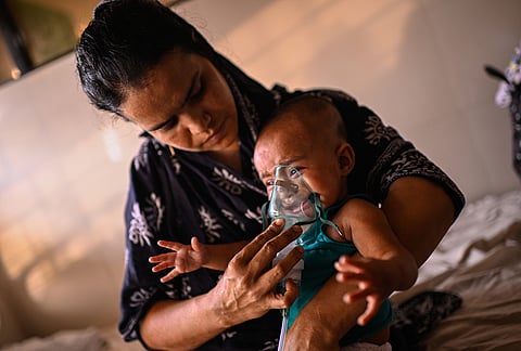 A mother administers a nebulizer treatment for her child suffering from measles at the Infectious Diseases Hospital in Dhaka, Bangladesh amid a countrywide outbreak. 