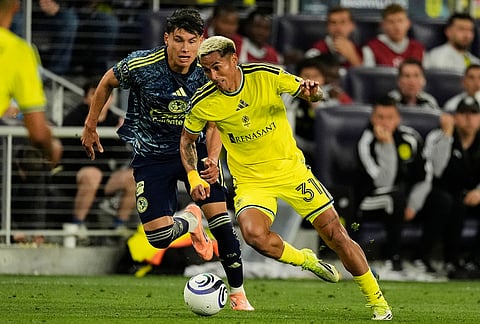 Nashville SC defender Andy Najar, right, moves the ball past Club America defender Miguel Vazquez, left, during the second half of an CONCACAF Champions Cup first leg quarterfinal soccer match in Nashville, Tennessee.