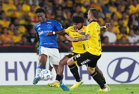 Jonathan Jesus of Brazil's Cruzeiro, left, fights the ball with Luis Cano, center, and Dario Benedetto, both of Ecuador's Barcelona during a Copa Libertadores soccer Group D match in Guayaquil, Ecuador.