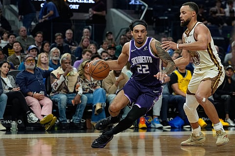 Sacramento Kings guard Devin Carter (22) moves the ball while defended by Golden State Warriors guard Stephen Curry (30) during the first half of an NBA basketball game in San Francisco.