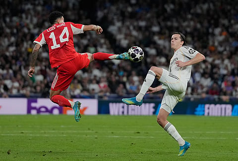 Real Madrid's Alvaro Carreras, right, and Bayern's Luis Diaz challenge for the ball during the Champions League quarterfinal first leg soccer match between Real Madrid and Bayern Munich in Madrid, Spain.